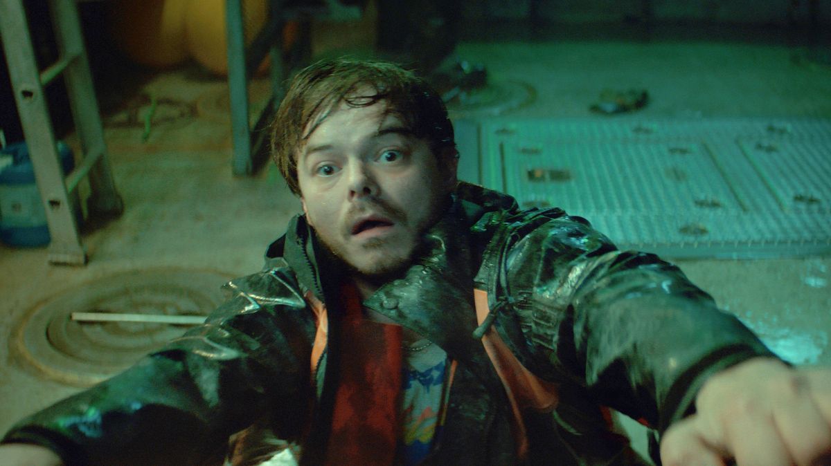 Charlie Heaton in Netflix's "Below" – A group of people appear haunted while standing on a boat and gazing out across the water.