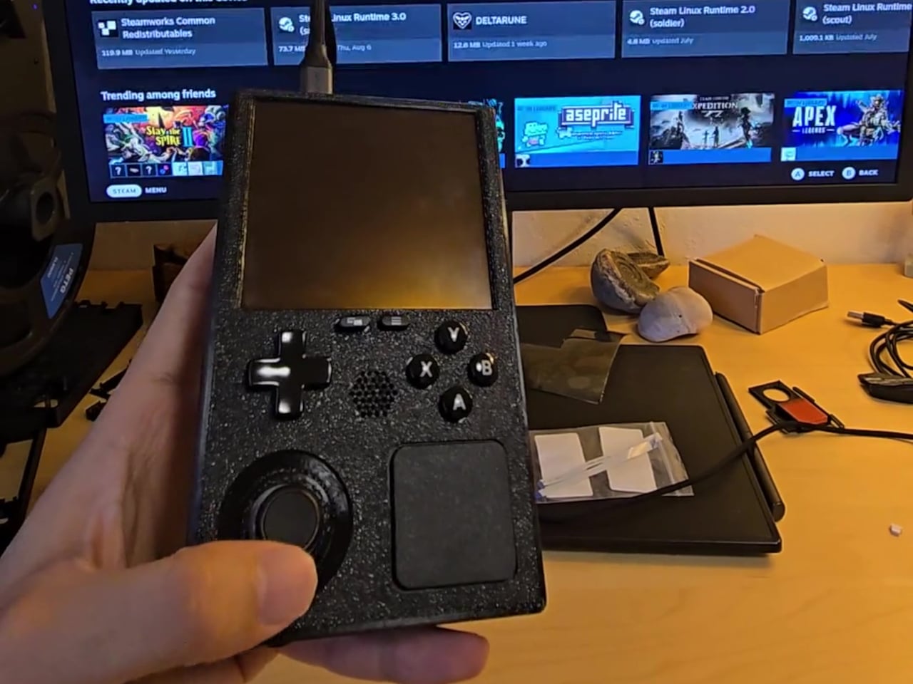 Representação de um Steam Deck modificado em um chassi vertical impresso em 3D semelhante a um Game Boy.