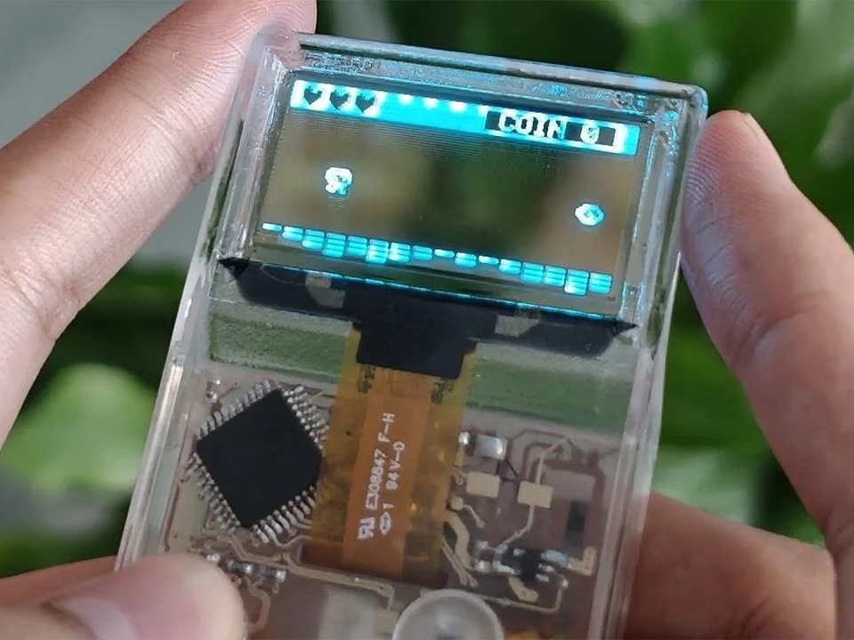 Representação do console portátil Arduview com carcaça, placa de circuito e tela OLED transparentes.